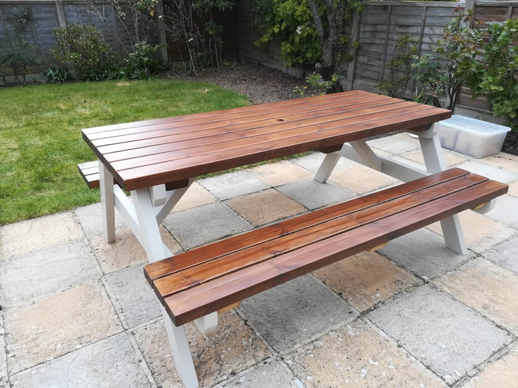 varnished and painted picnic table in a back garden