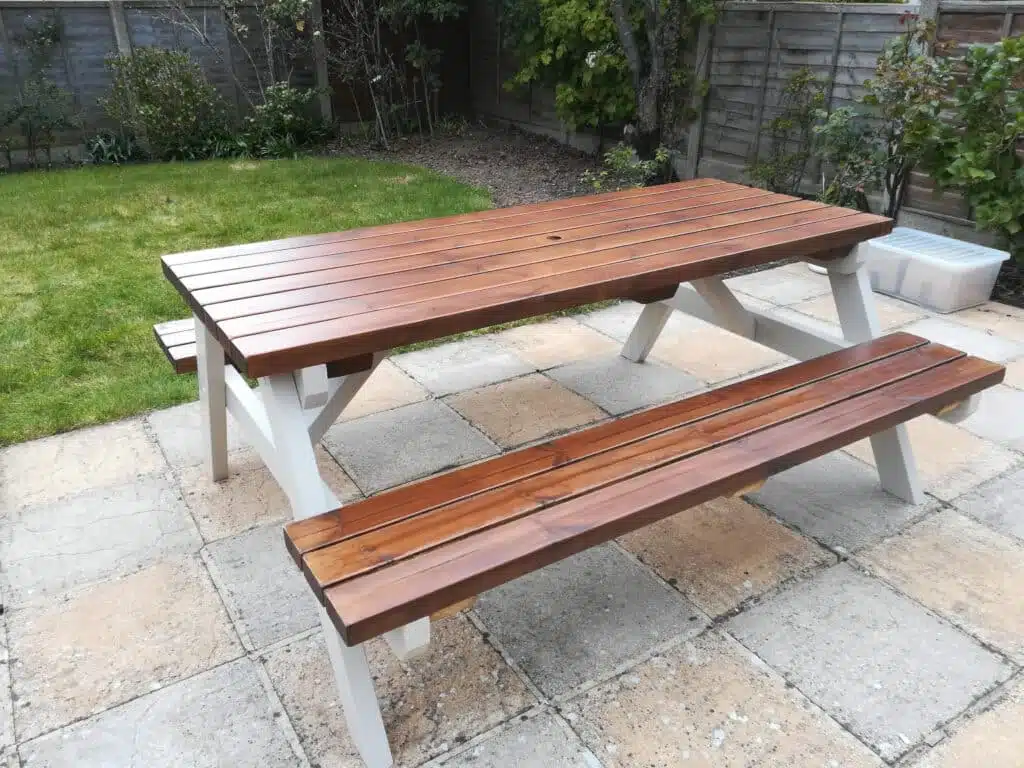 varnished and painted picnic table in a back garden