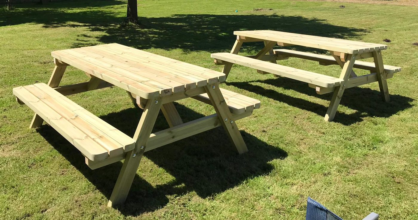 two a frame picnic tables in the field of a farm