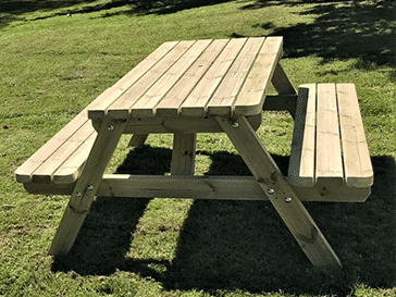 a standard wooden picnic table in the garden