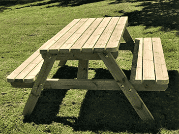 a standard wooden picnic table in the garden