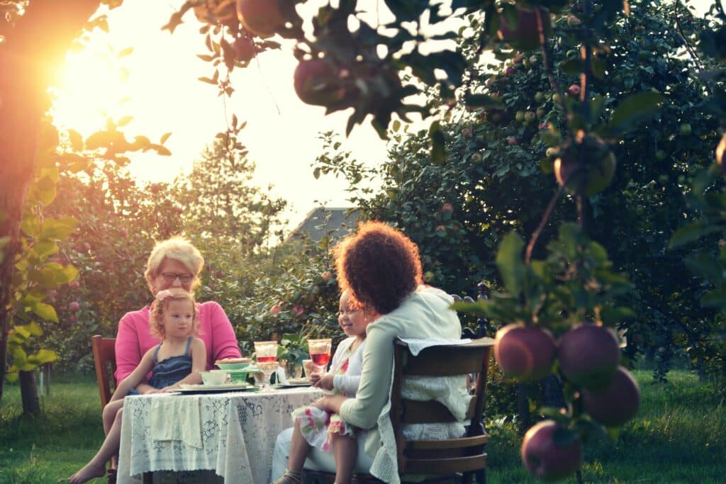 two grandma's and grandchildren eating together outside