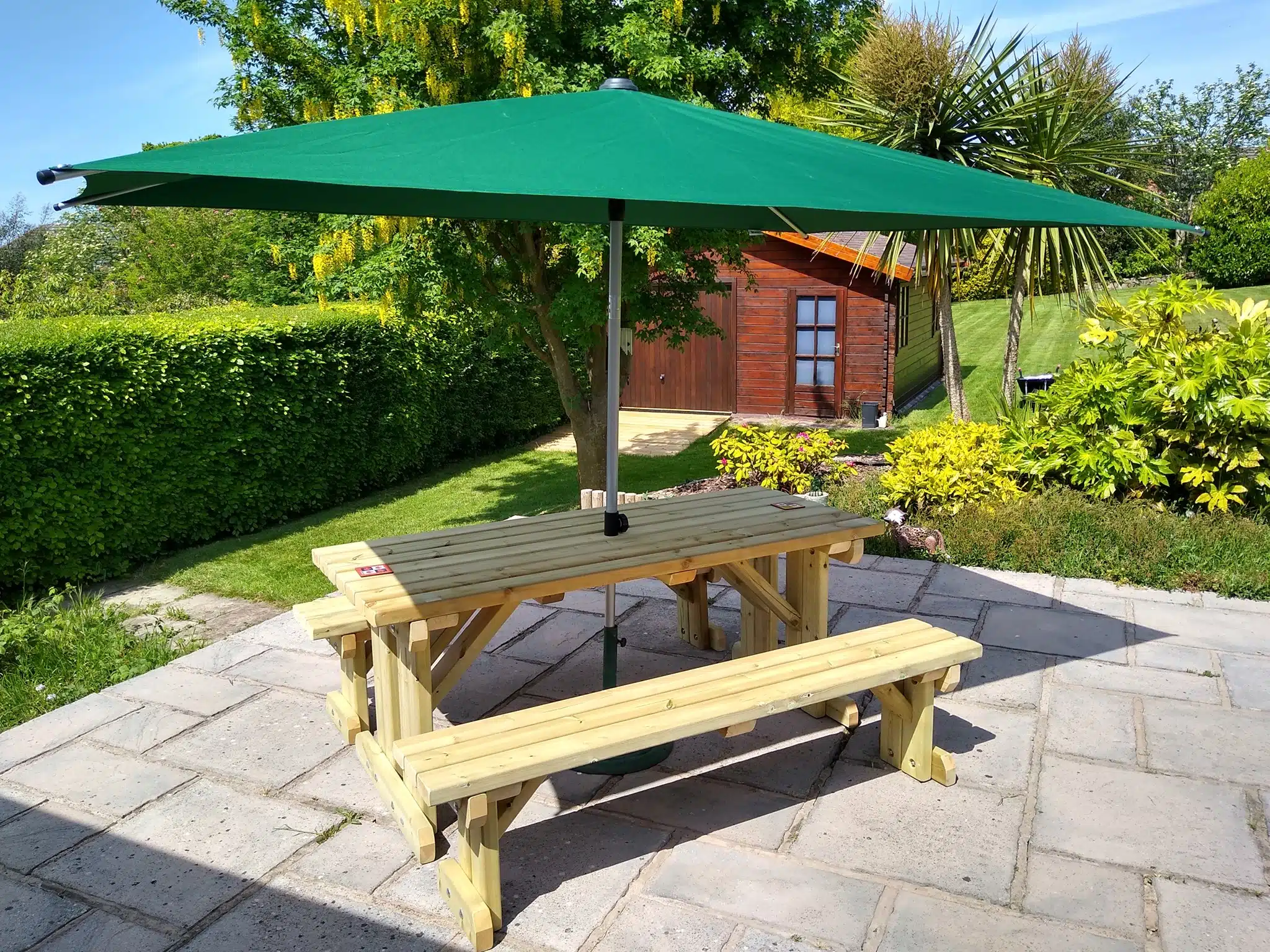 picnic bench with parasol in garden