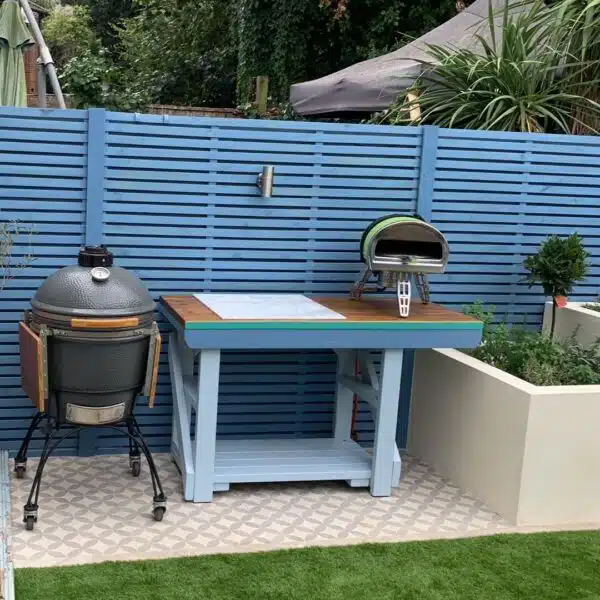 Custom BBQ and pizza table painted blue. Two BBQs placed next to and on-top of table.