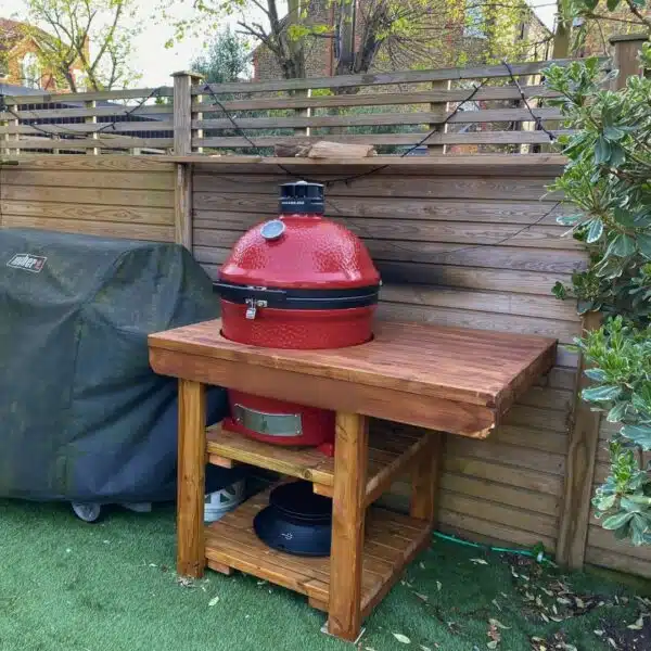 Custom BBQ table with cut-out holding Big Green Egg (red) BBQ