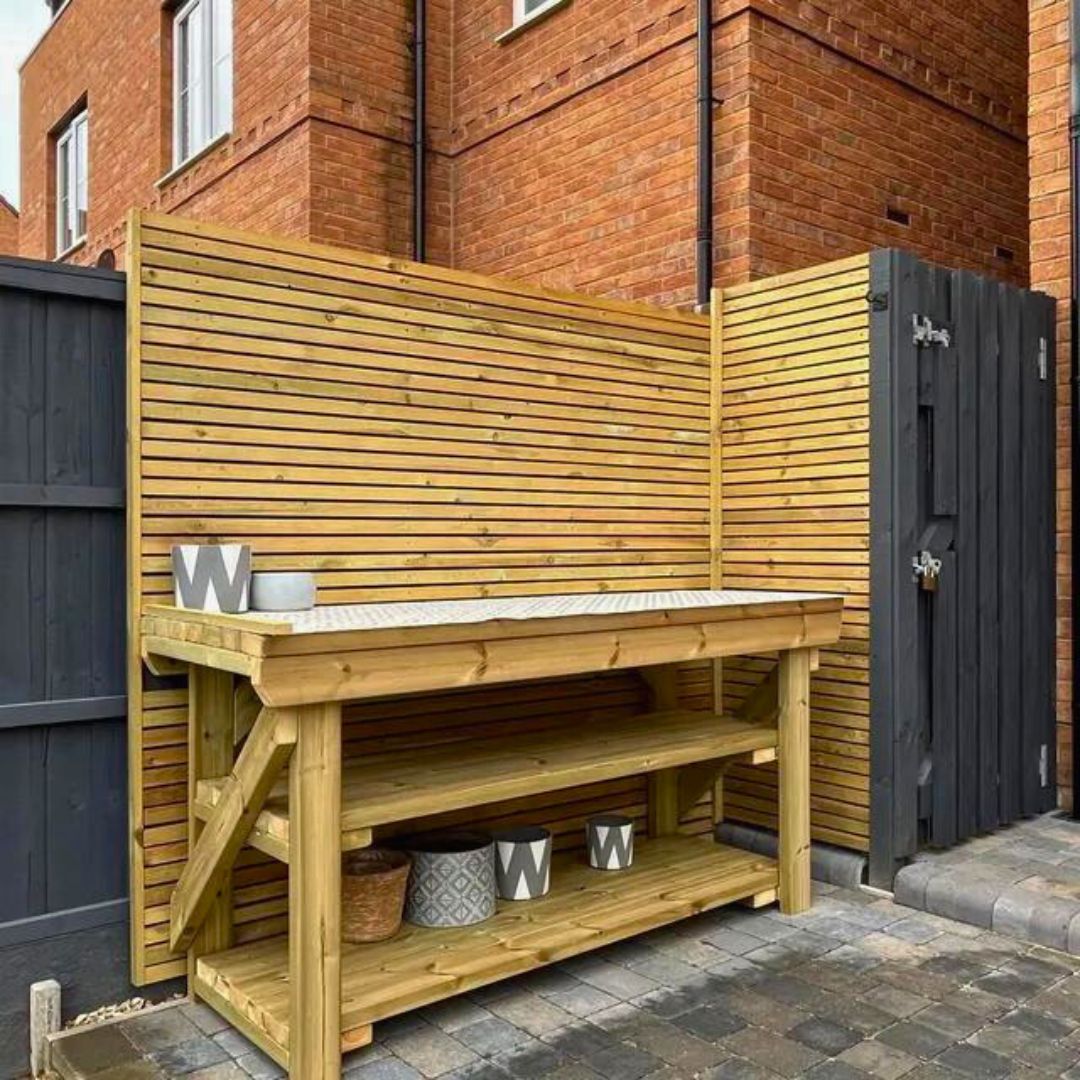 Custom wooden workbench used outdoors placed against wood panelling
