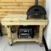 Wooden workbench with wheels storing BBQs