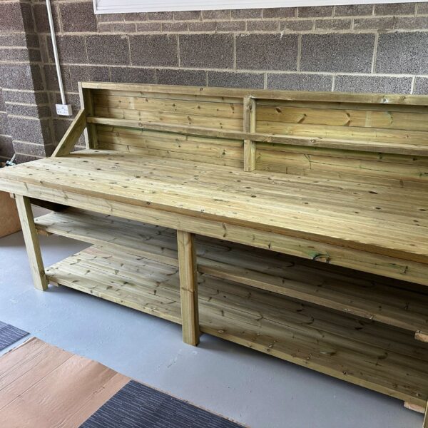 Large indoor wooden workbench with backboard