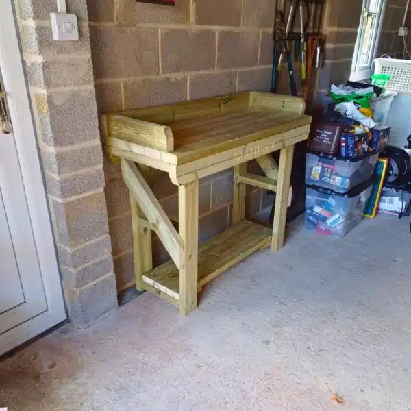 Wooden potting table placed against a lean-to wall