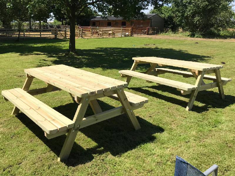 commercial two a frame picnic tables in the field of a farm