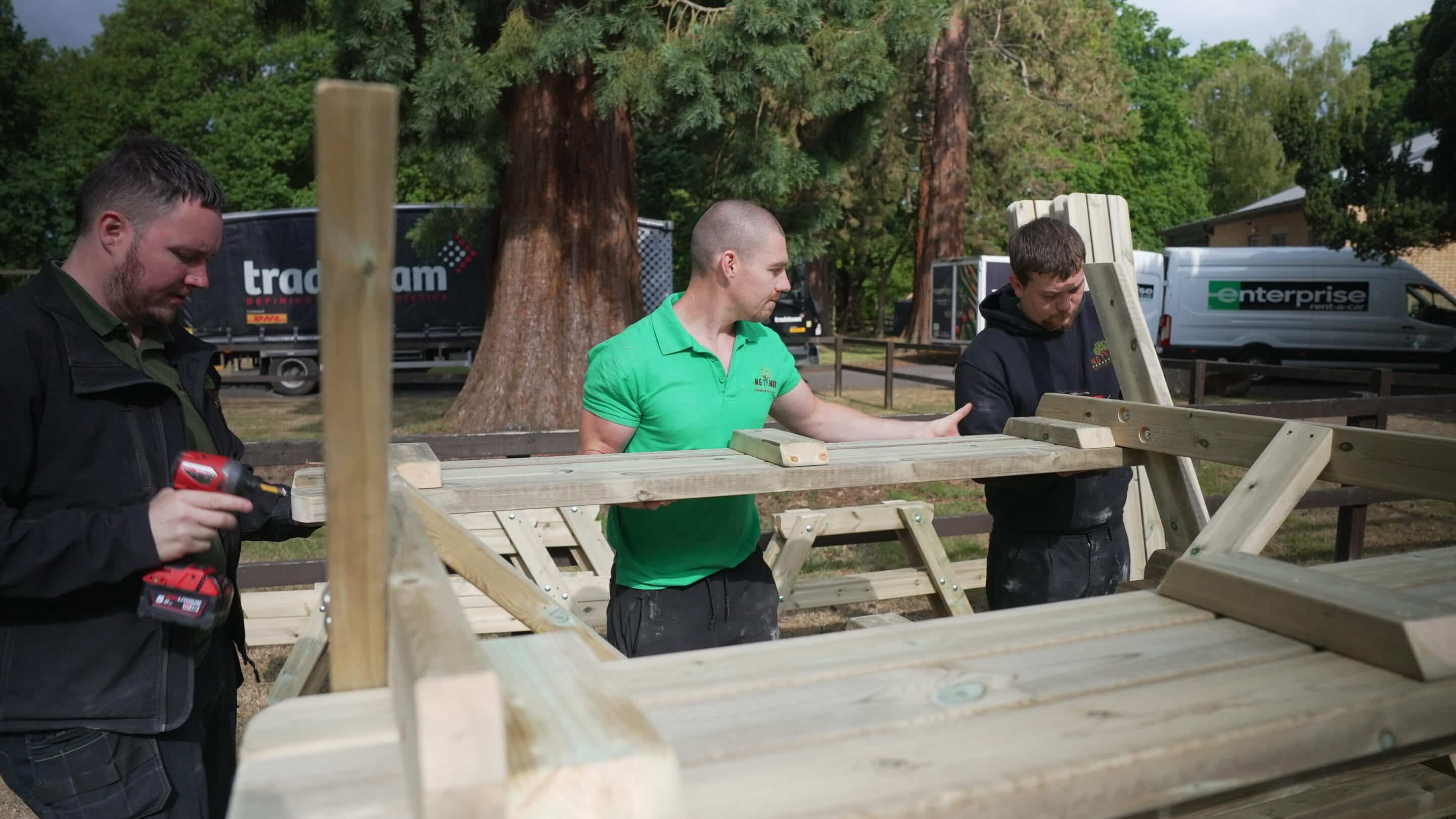 Men building wooden picnic benchs for hospitality